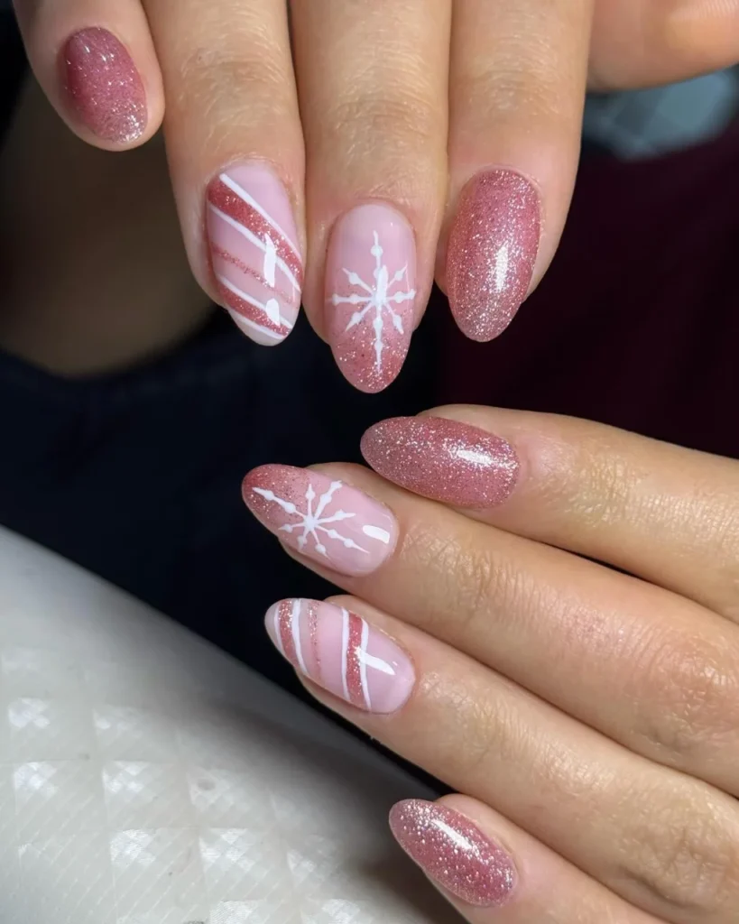Christmas glitter ombre nail designs featuring pink glitter fades, white snowflakes, and candy cane stripes on almond-shaped nails.