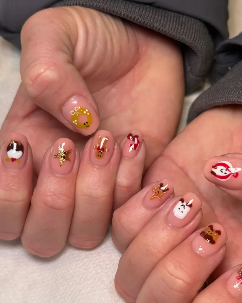 Classy Christmas short nail designs with a nude pink base, cute reindeer, Santa faces, snowmen, golden stars, and festive holiday nail art.