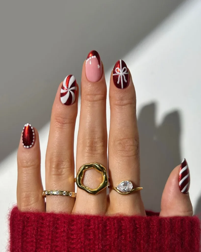 Classy Christmas short nail designs featuring burgundy red shimmer, white peppermint swirls, a gift bow, and delicate white dot accents.