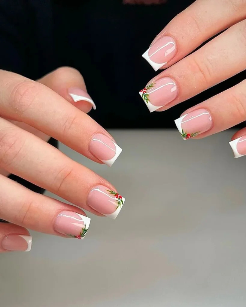French manicure Christmas nail designs featuring glossy pink nails, crisp white square French tips, and delicate green holly leaves with tiny red berries.