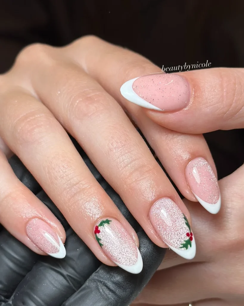 French manicure Christmas nail designs with pink glitter nails, crisp white French tips, and delicate green holly leaves with red berries.