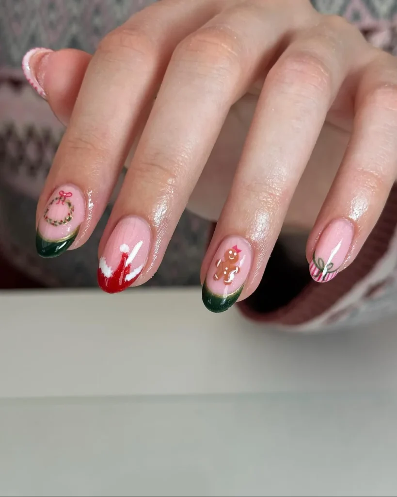 Green Christmas French tip nail designs with dark green tips, a miniature wreath, red and white accents, a gingerbread man, and a festive bow on a pink base.