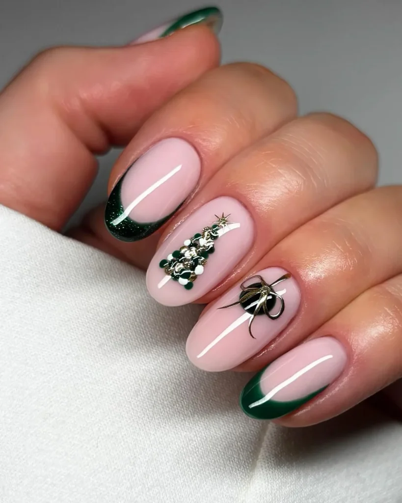Green Christmas French tip nail designs with deep emerald glitter tips, a pink nude base, a festive green and gold Christmas tree, and a metallic bow accent.
