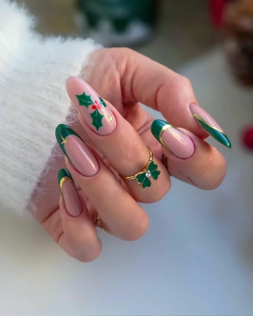 Green Christmas French tip nail designs with deep emerald tips, nude pink bases, gold accent lines, and holly leaves with red berries.