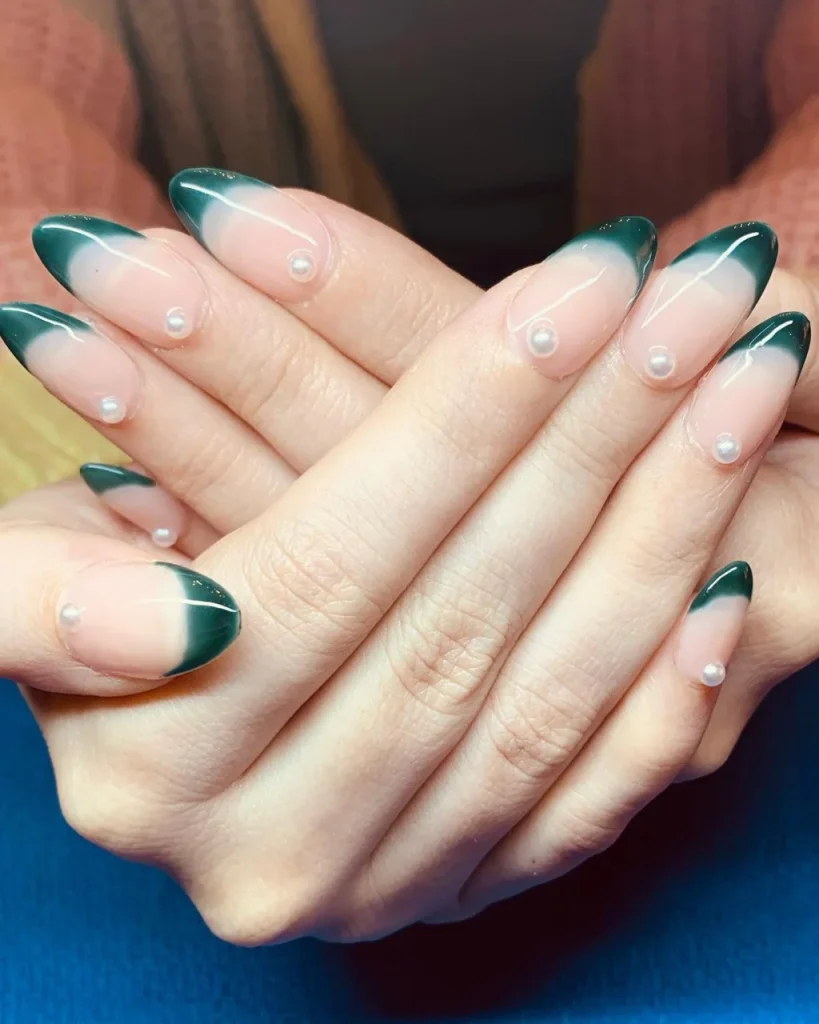 Green Christmas French tip nail designs with sheer pink bases and delicate pearl accents.