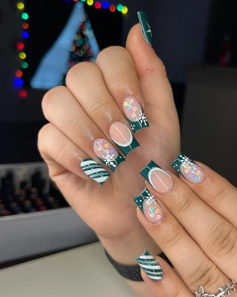 Green Christmas French tip nail designs with dark teal tips, white snowflakes, iridescent glitter, silver stripes, and nude pink accents.