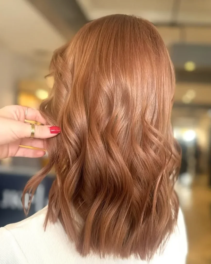 Light brown cinnamon hair color with glossy copper tones and soft waves