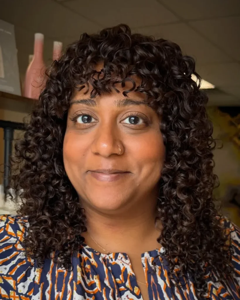 Light chocolate brown hair color on natural curls and coils with glossy dark brunette tones and defined spiral curls