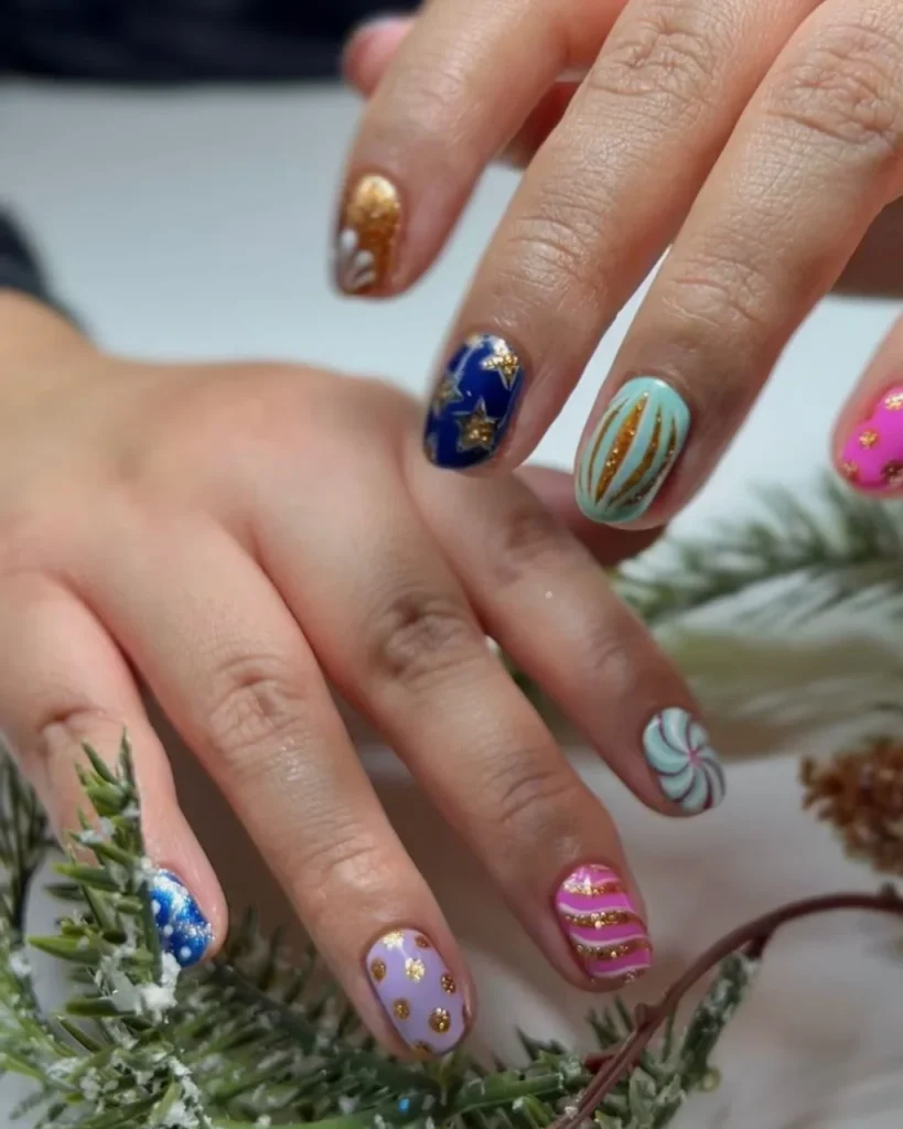 Light pink Christmas bauble nails featuring miniature festive ornaments on a glossy pink manicure.