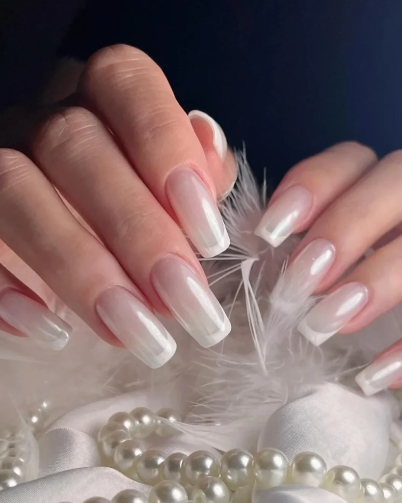 Milky pink nails with pearly white chrome tips and a frosted finish for Christmas.