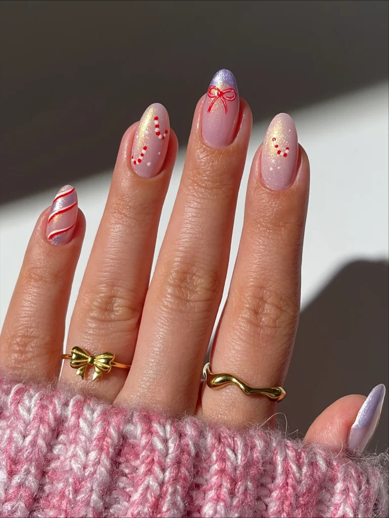 Short Christmas press on nail designs featuring pink shimmer nails, red-and-white candy canes, a red bow, and lilac chrome accents.