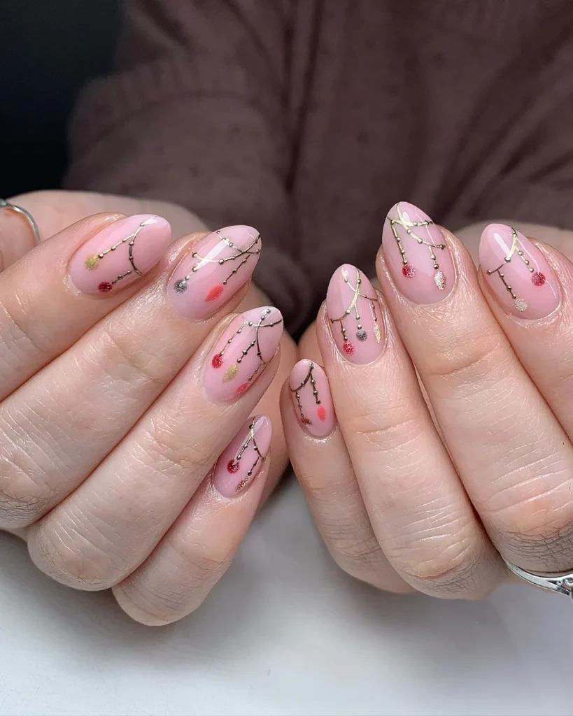 Short Christmas press-on nail designs featuring glossy pink nails with delicate gold garland lines and tiny red, gold, and silver ornament accents.