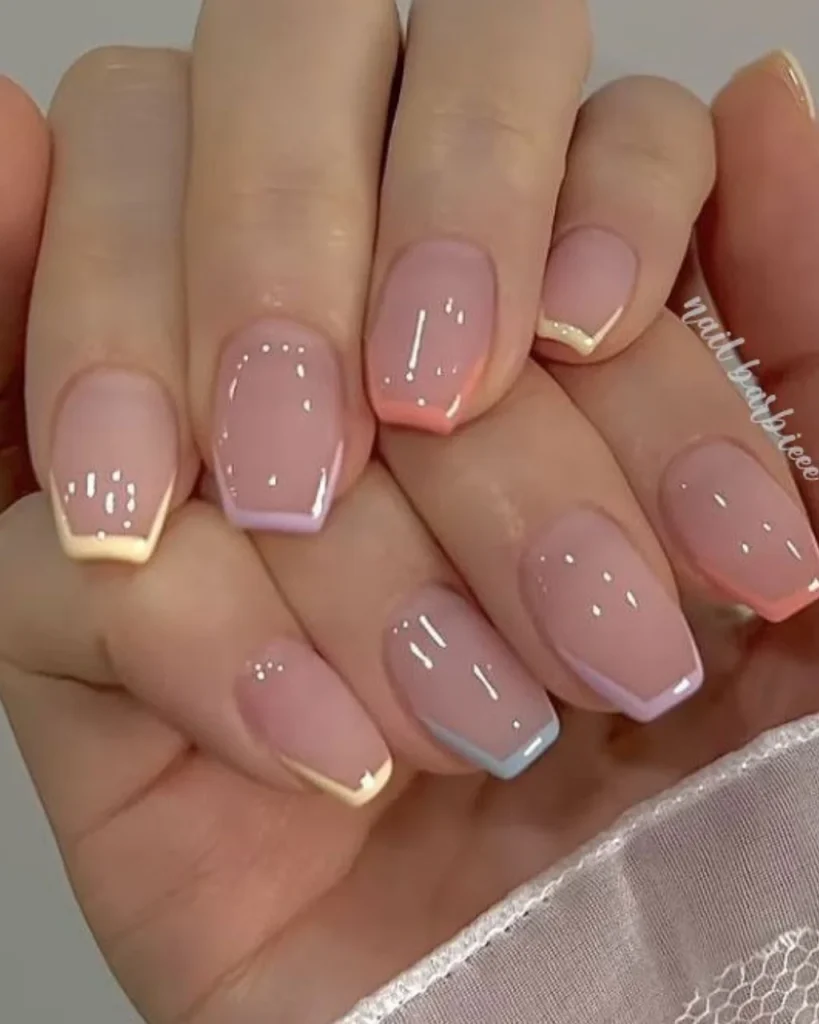 Short french tip christmas nail designs featuring glossy nude pink nails with pastel blue, lavender, peach, and cream French tips.