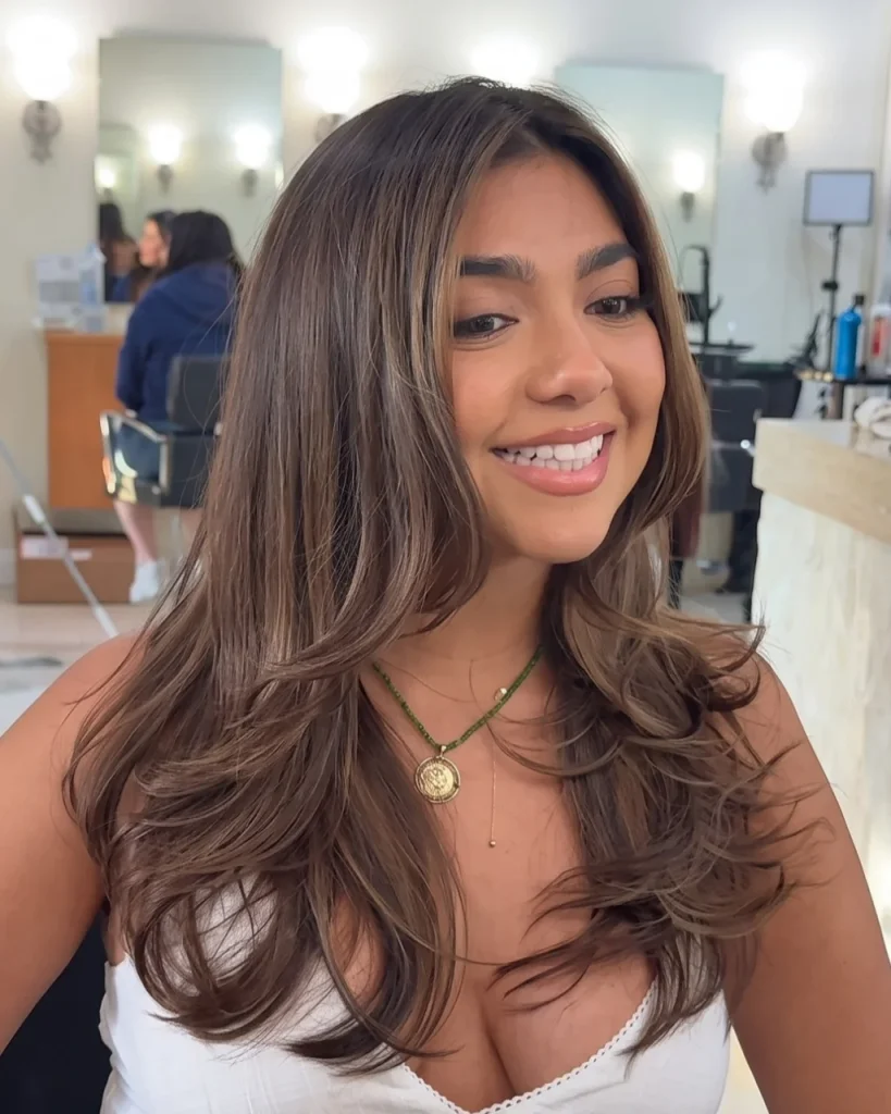 honey brown
balayage with subtle caramel highlights, dimensional brunette tones, face-framing layers, and voluminous feathered waves