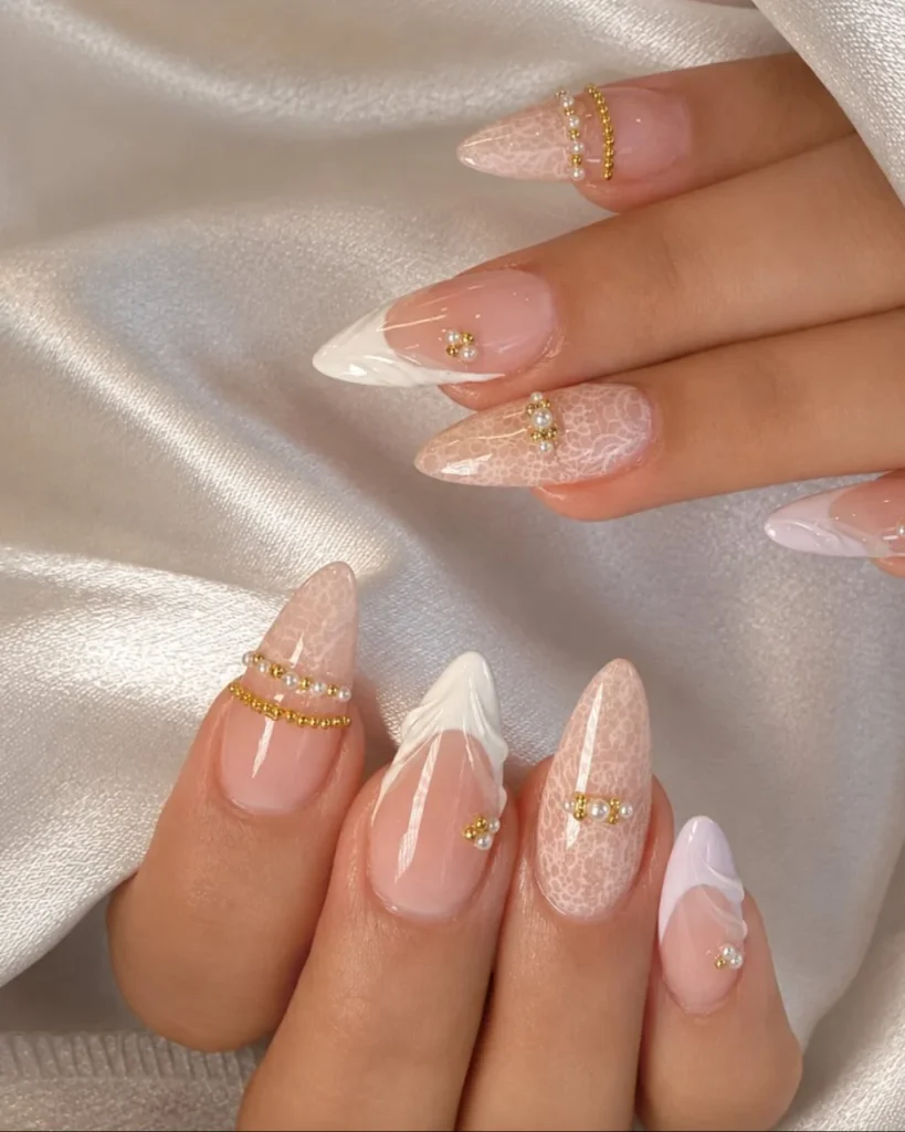 White French tip Christmas nail designs with sheer pink bases, delicate white lace patterns, and tiny gold and pearl accents.