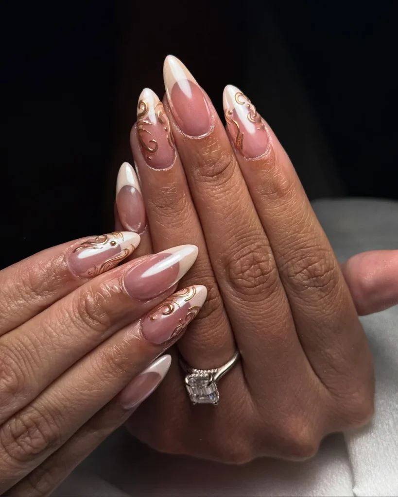 White French tip Christmas nail designs with sheer pink bases, delicate white lace patterns, and tiny gold and pearl accents.